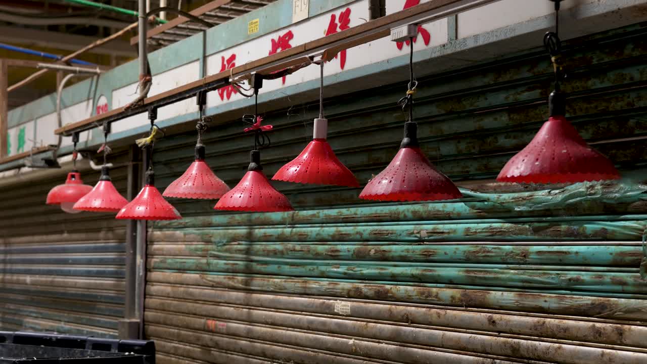 Late-night view of red lanterns hanging at a closed stall in a Hong Kong wet market, showcasing traditional Chinese market decorations.