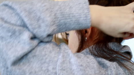 아름다운 여자가 집에서 머리카락을 고치고 있습니다.