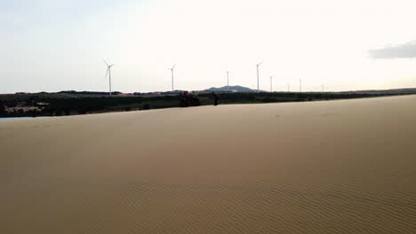 Aerial-of-tourists-with-quad-bike,-windmills-in-background