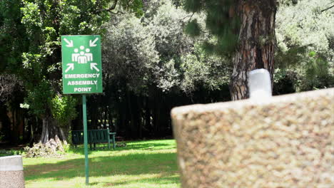 emergency assembly point sign at zoo, panning shot right to left