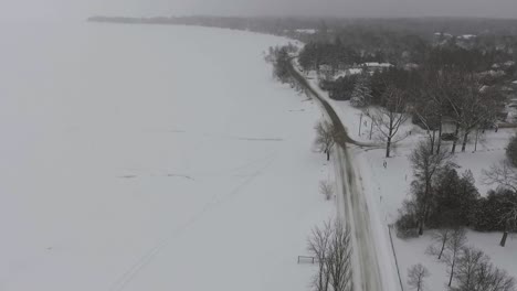 Drone-Volando-Sobre-La-Orilla-Del-Lago-Congelado-Y-Nevado-En-El-Sur-De-Ontario