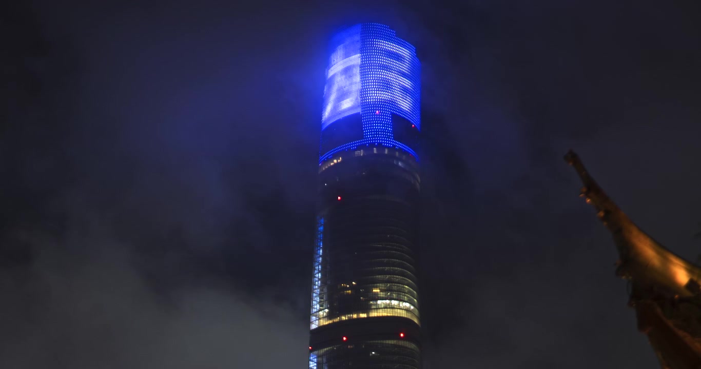 Torre di Shanghai illuminata di notte tra nuvole basse
