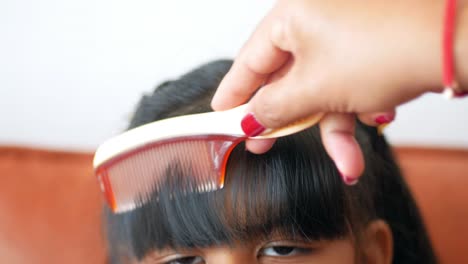 madre peinando el cabello de su hija