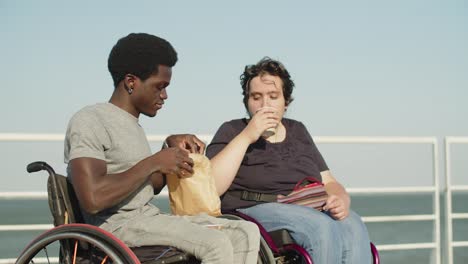 happy couple with disability drinking coffee and having snack