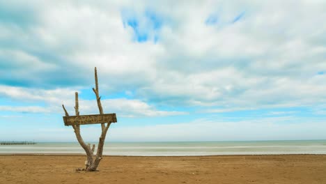 time lapse of the clouds on the sandy beach. you can see the board of the bar called gradela. it's partly sunny and partly cloudy. taken by the sea of   italy, rimini. beautiful natural landscape