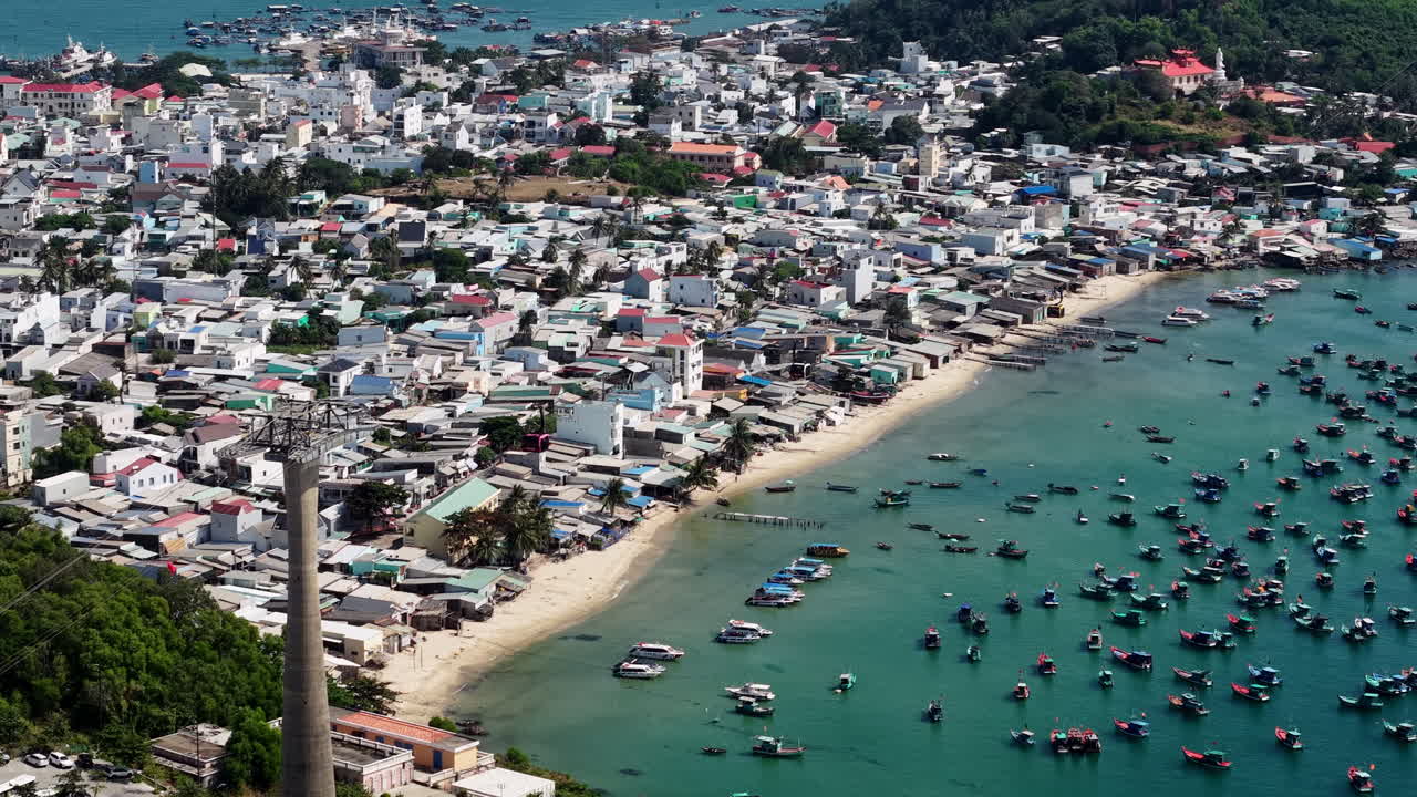 Ripresa con drone delle cabine della funivia di Sunset Town che si muovono sopra la spiaggia e gli edifici del villaggio, sull'isola di Phu Quoc, Vietnam.