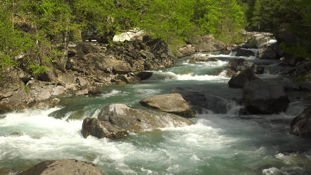 Río de montaña caudaloso con un todoterreno circulando, Pirineos, España