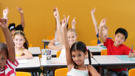 school kids raising hands in classroom