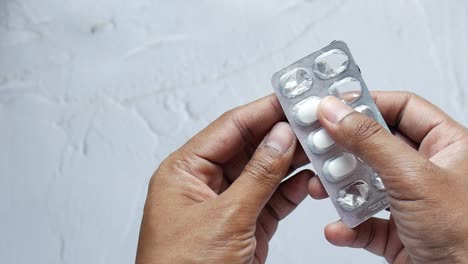 person holding a blister pack of pills