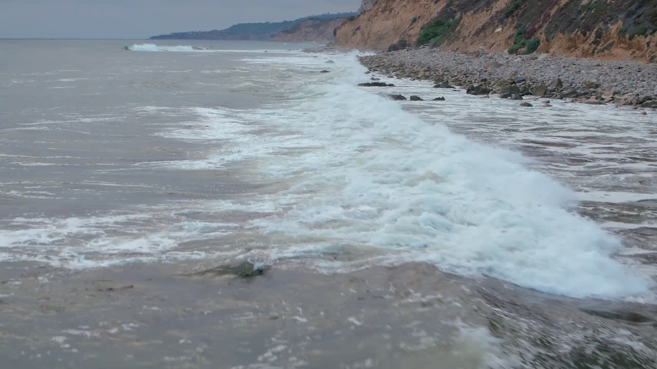 바위가 많은 남부 캘리포니아 해변에서 부서지는 파도의 하향식 조감도 공중 전망