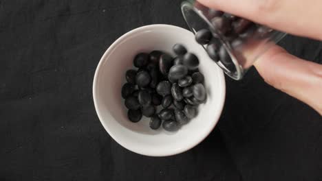 close-up of black turtle beans pouring into a bowl, a healthy vegan protein source