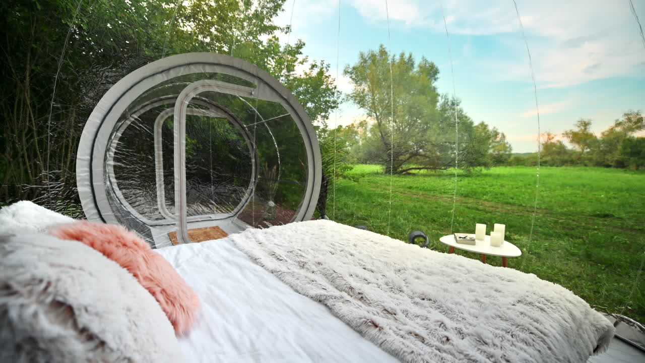Gennemsigtigt bobletelt ved glamping, frodig skov rundt om og interiør. Udsigt indefra