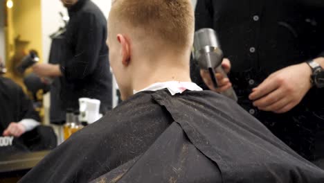 un hombre se corta el cabello en la barbería.