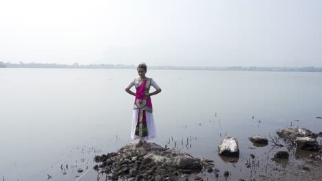 A-bharatnatyam-dancer-displaying-a-classical-bharatnatyam-pose-in-the-nature-of-Vadatalav-lake,-Pavagadh