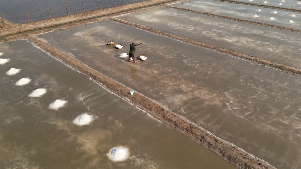 Riprese con drone sopra un lavoratore in una salina nella provincia di Kampot, Cambogia.