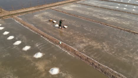 drone footage above a worker in a salt field in kampot province, cambodia