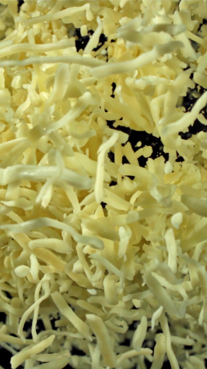 Primo piano di formaggio grattugiato su sfondo scuro
