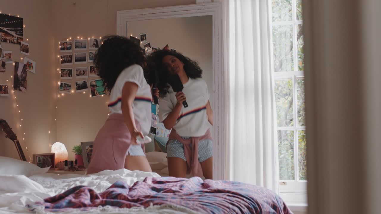 happy teenage girl dancing in bedroom enjoying music celebrating weekend having fun singing wearing pajamas at home