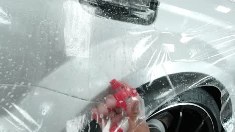 close up to ppf installation process on silver sports car