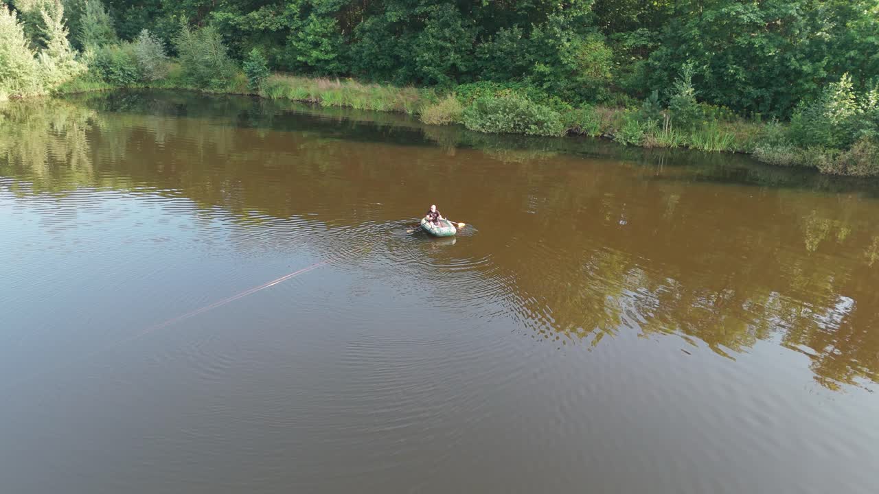 Rowing on a pontoon, taking carp sets over the pond to the other bank