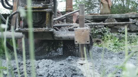 the moment bore well digging machine hits water table water bursts out of the ground slow motion