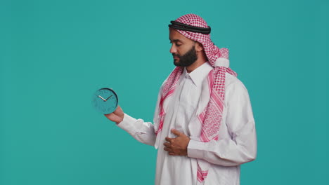 adulto islámico mira el reloj de pared