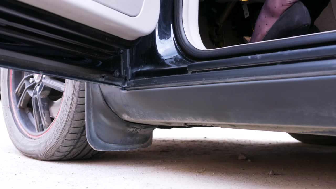 una mujer saliendo de un coche.