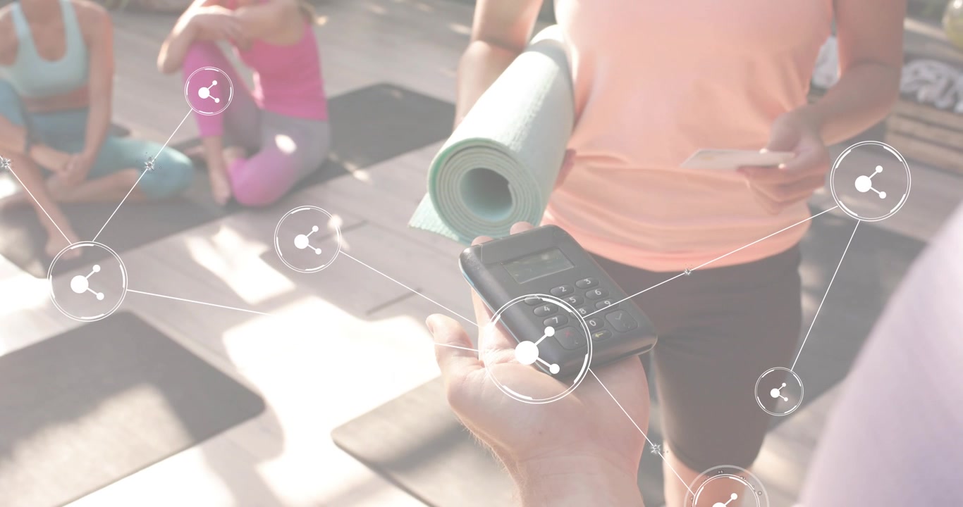 Participante de pie tocando una tarjeta de pago y activando iconos para compartir en un lector, preparando una clase de yoga.