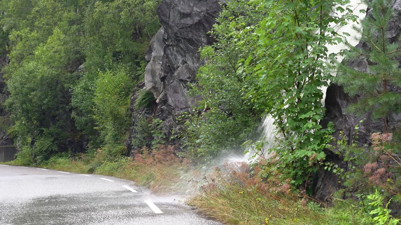 노르웨이 서부 에서 폭우 가 강하게 내리면서 도로 에  ⁇ 아지는 도로변 폭포