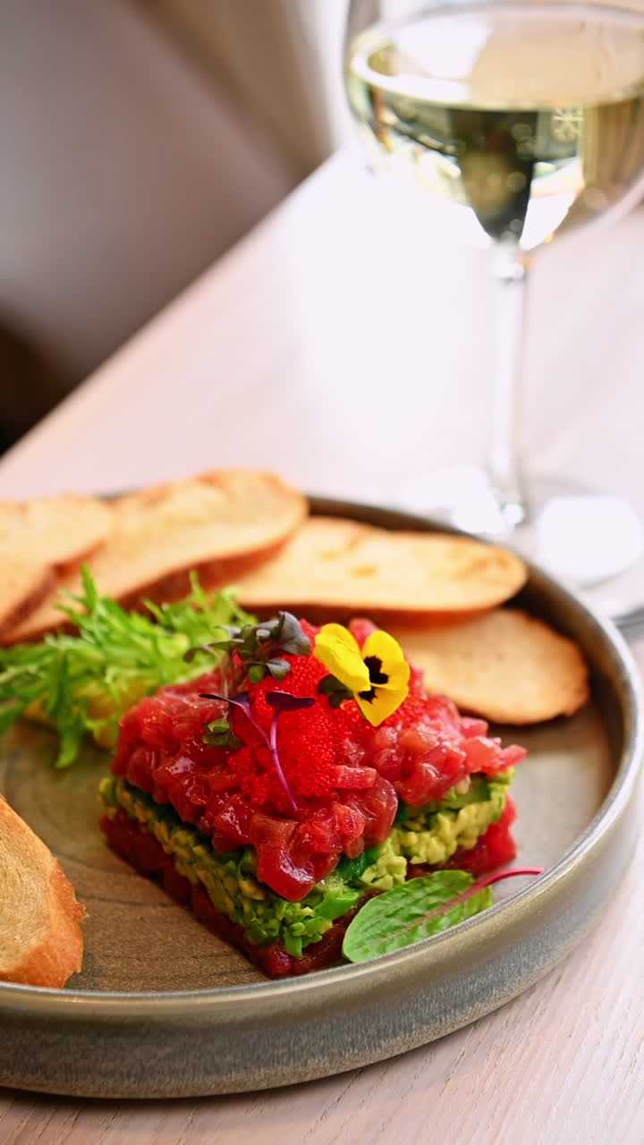Tartare di tonno con pane tostato. Tartare di tonno fresco con avocado e pane tostato su un tavolo di ristorante