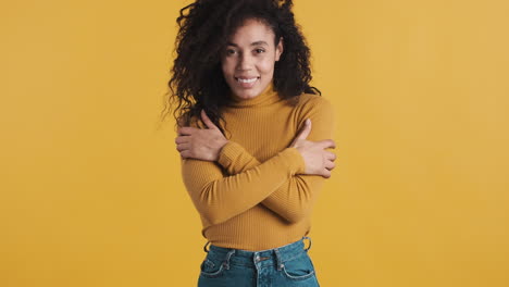 african american happy woman over orange background.