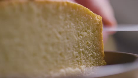 close up of man in kitchen at home cutting freshly baked cake on work surface 2