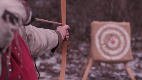 warrior woman shoots a bow in the target