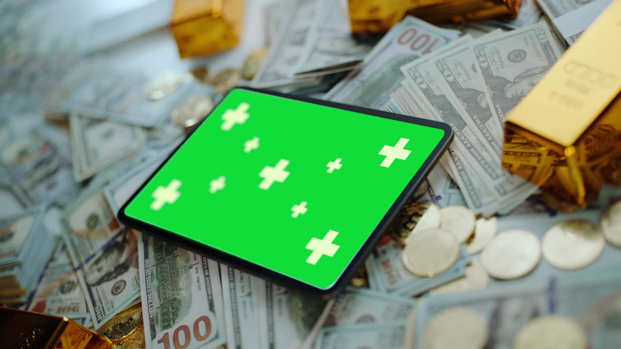 Tablet with green screen on money and gold