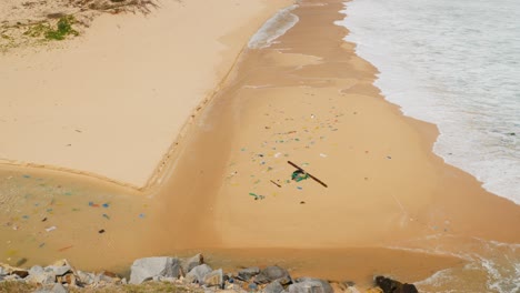 Productos-De-Plástico-De-Un-Solo-Uso-Arrastrados-A-Tierra-Traídos-A-La-Playa-Por-Las-Olas