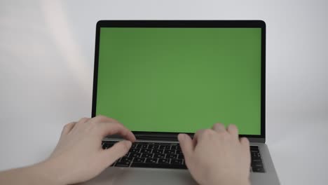 close up green screen mock up on laptop computer. person uses device keyboard