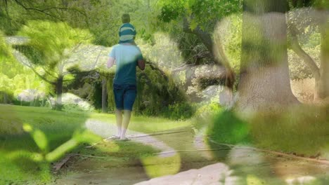 composite video of close up of leaves against rear view of father carrying his son on his shoulders