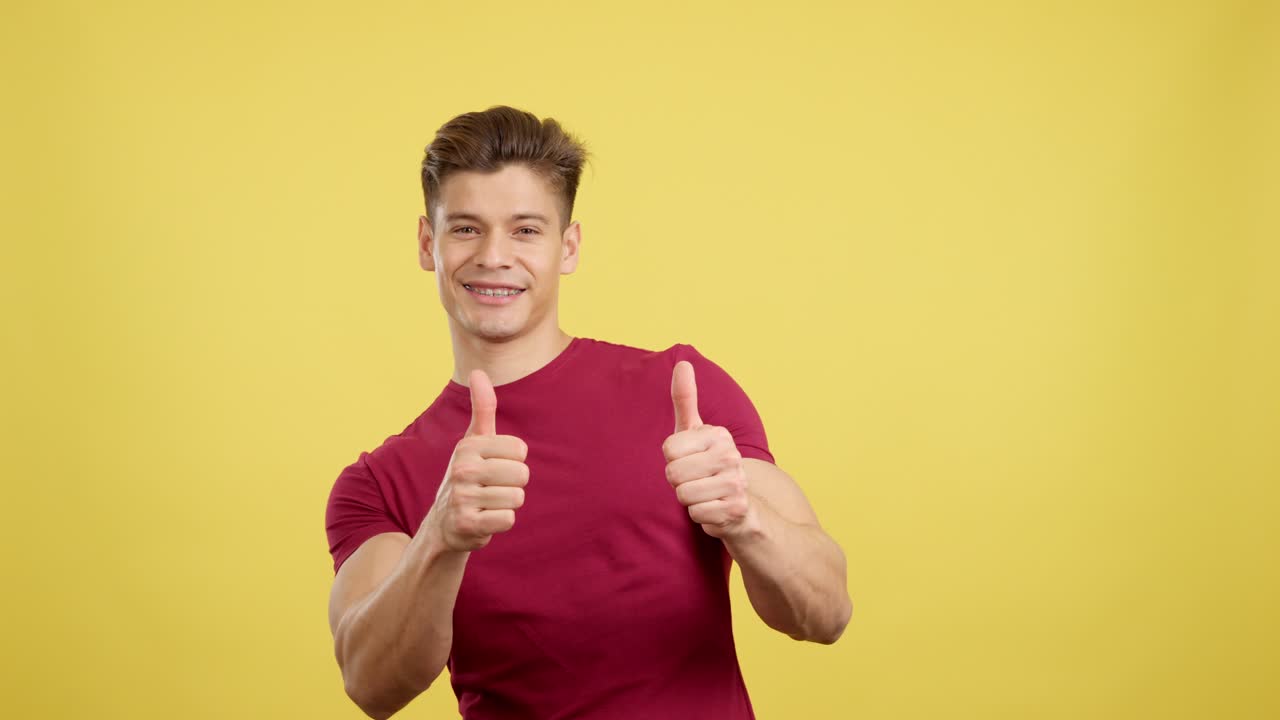 Young man with braces smiling and giving thumbs up