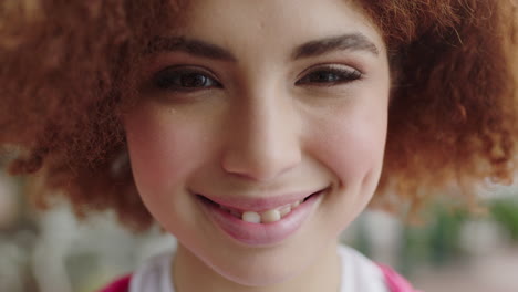 retrato en primer plano de una joven estudiante adolescente feliz sonriendo juguetona mirando a la cámara una mujer linda con un peinado afro de moda