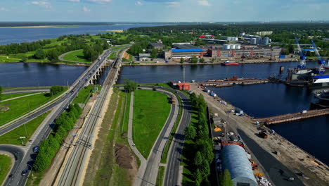 a riverside port with roads, railway lines, and industrial buildings, aerial view