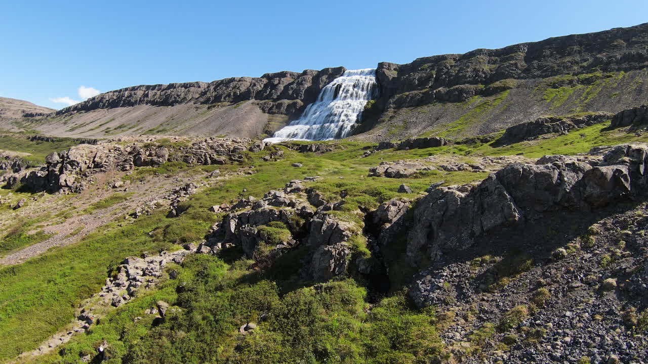 turistas explorando la cascada dyjandi en un día soleado