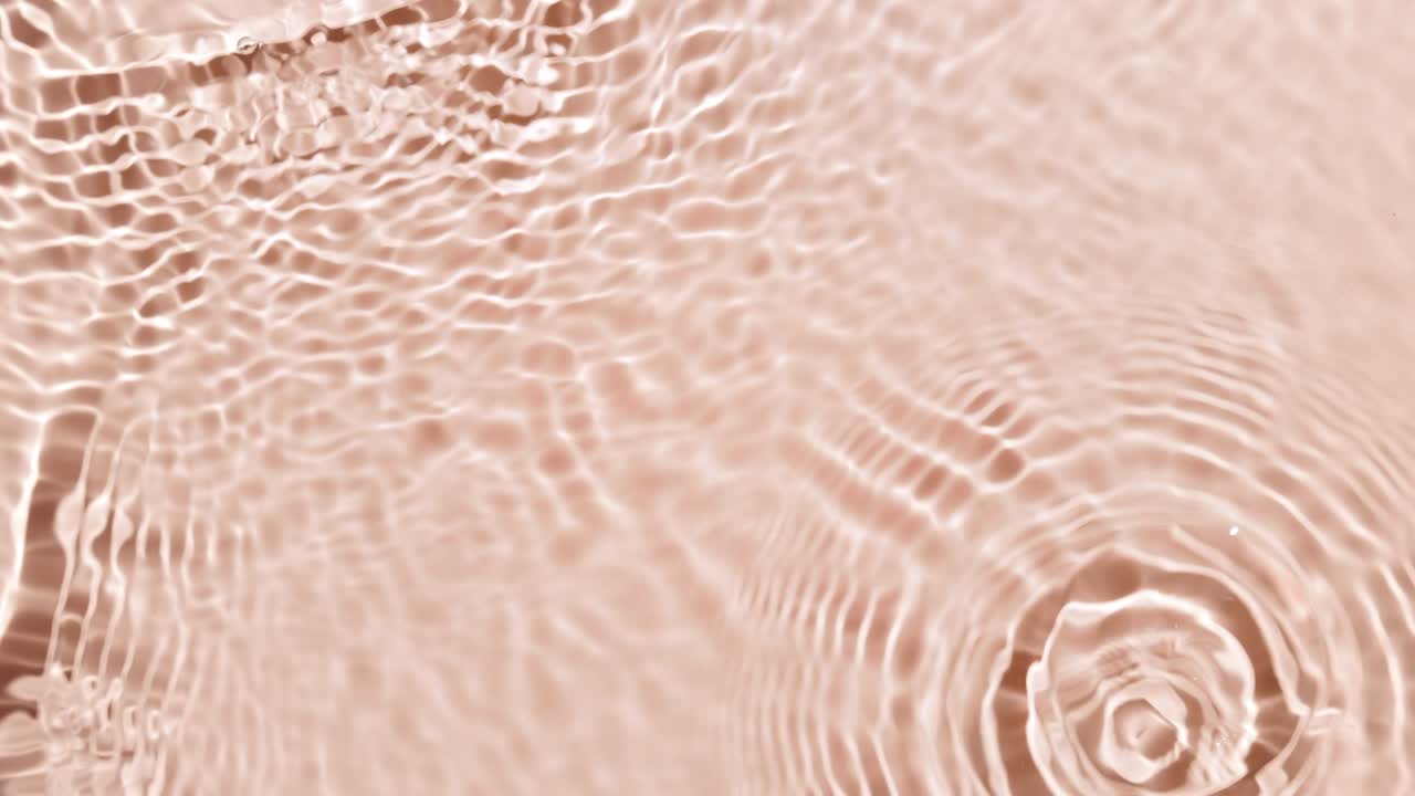 Multiple water drops falling in water with waves on beige bg