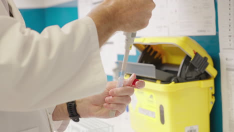 primer plano de científico en bata blanca de laboratorio pipeteando en tubo de ensayo en laboratorio de investigación médica, 4k