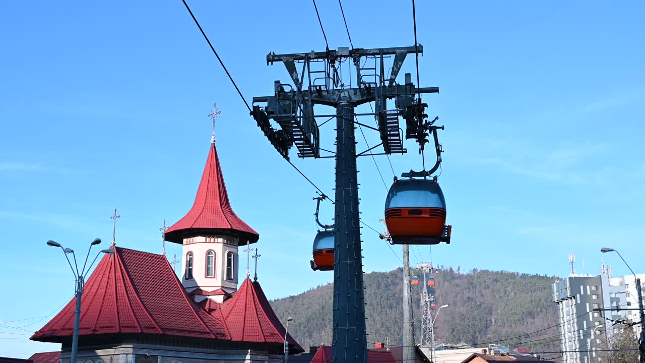 Gondola lift moving above Piatra Neamt, Romania, near the Pogorarea Sfantului Duh - Gara Church
