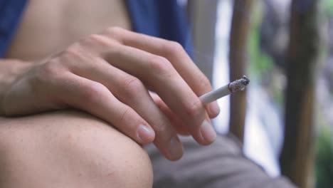 man smoking, close-up of his hand.