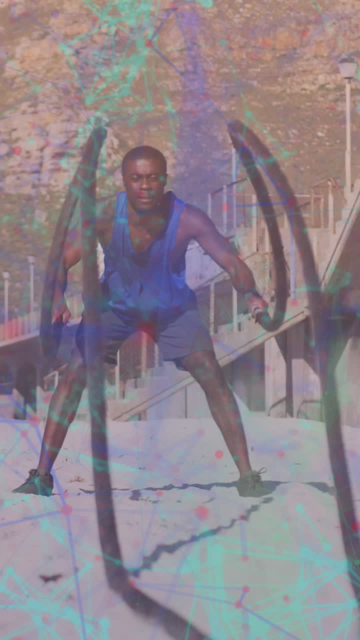 un hombre afroamericano hace ejercicios con una cuerda en la playa, mostrando tecnología deportiva.