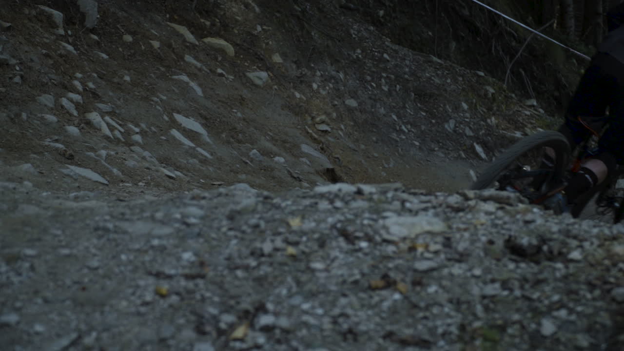 Close up shot of a downhill racer riding down a steep passage in the trail on one wheel. Downhill park in Semmering Austria. Footage slowed down eight times
