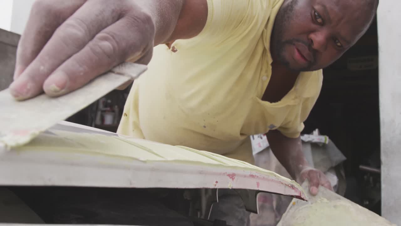 African man painting a car