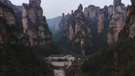 a bus station set against the towering sandstone pillars of zhangjiajie, providing travelers with a unique transit hub surrounded by breathtaking mountain landscapes and lush greenery.