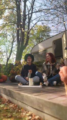 two friends enjoying a fall day by the camper